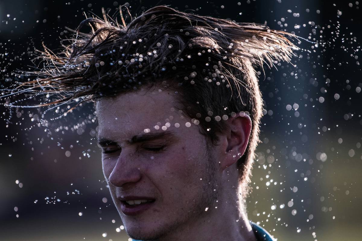 Man applying styling spray for men with proper distance and technique